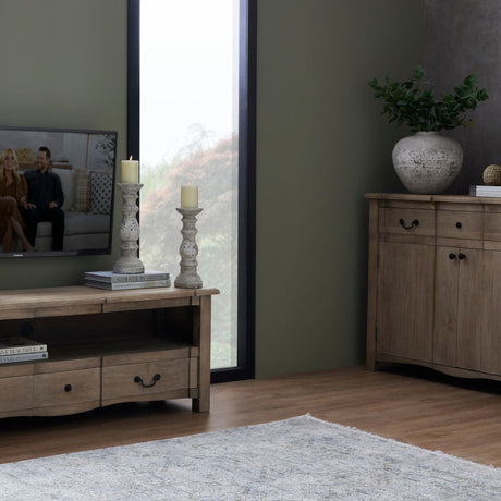 Hill Interiors Large Stone Ceramic Column Candle Holders in beige, paired on books beside a window, styled with a wooden TV unit and sideboard.