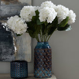 Hill Interiors Ceramic Indoor Planter in blue with scalloped glazed pattern, holding white hydrangeas beside a smaller textured blue pot on a sideboard.