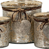 Hill Interiors mercury glass heart candle holders in silvered mottled finish, tied with jute twine and hammered metal heart charms, shown grouped together.