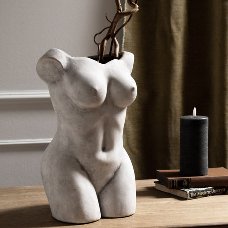 Hill Interiors beige ceramic Female Figure vase with matte sculptural torso, styled with tall twisted branches on a wooden console beside books and a candle.