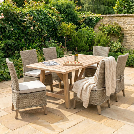 Hill Interiors beige powder-coated metal outdoor dining chairs set around a wooden garden table with wine and pizza on a sunny patio.