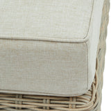 Close-up of Hill Interiors Outdoor Foot Stool showing the beige woven cushion top with piped edging and pale rattan-style base.