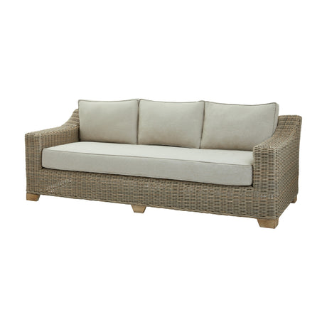 Hill Interiors Rattan Three-Seater Garden Sofa in beige with woven frame, wooden feet and three back cushions over a long seat pad, on a white background.