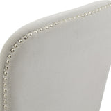 Close-up of the Hill Interiors Grey Wooden Dining Chair showing the curved backrest in soft grey woven upholstery trimmed with polished silver nailhead studs.