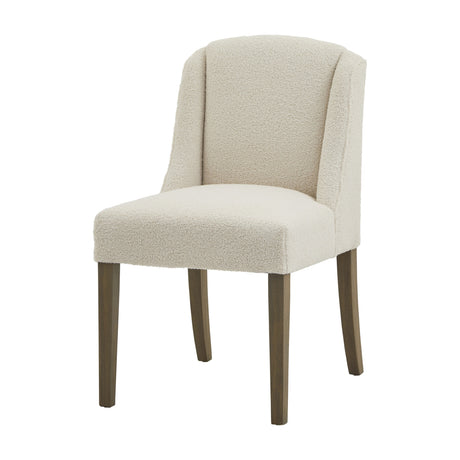 Hill Interiors Braxdon cream bouclé dining chair with curved wingback, upholstered seat and tapered wooden legs on a plain white background.