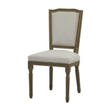 Hill Interiors Wooden Dining Chair in grey with a solid wood frame, upright nailhead-trimmed upholstered back and seat, on turned legs, plain background.