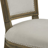 Close-up of Hill Interiors Wooden Dining Chair in grey, showing the upholstered seat and padded backrest with silver nailhead trim on a wood frame.