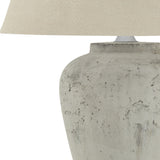 Close-up of the Hill Interiors Merenza ceramic table lamp base in antique white glaze with a natural linen shade on a plain background.