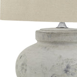 Close-up of Hill Interiors Merenza squat ceramic table lamp base in antique white glaze with textured finish, topped by a natural linen shade.