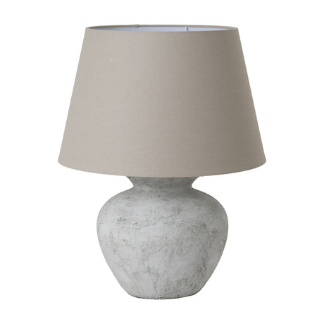Hill Interiors Merenza round ceramic table lamp with antique white glazed base and natural linen tapered shade, shown on a plain white background.