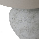 Close-up of the Hill Interiors Merenza ceramic table lamp base, showing its rounded antique white glazed form beneath a natural linen shade.
