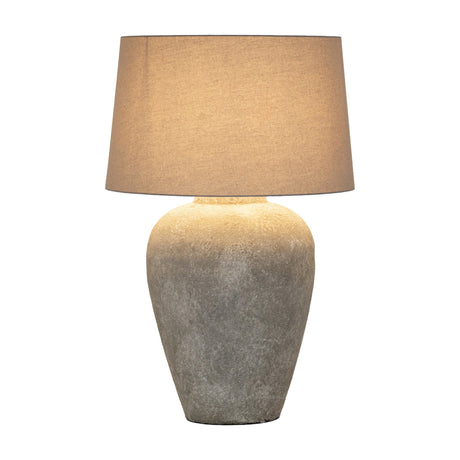 Hill Interiors Elvessa tall table lamp with aged stone effect ceramic base in beige and a tapered linen drum shade, on a plain white background.