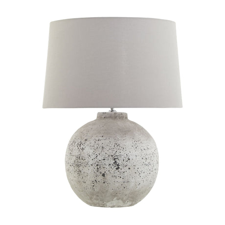 Hill Interiors Glavendor large ceramic table lamp with a spherical stone-textured beige base and tapered light grey drum shade on a white background.