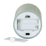 Underside of Hill Interiors Melt Effect LED Wax Candle in green, showing the battery compartment with springs, on/off switch, and removable white cover.