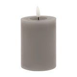 Hill Interiors Melt Effect LED wax pillar candle in grey with a realistic flame-shaped tip and melted top edge, shown against a plain white background.