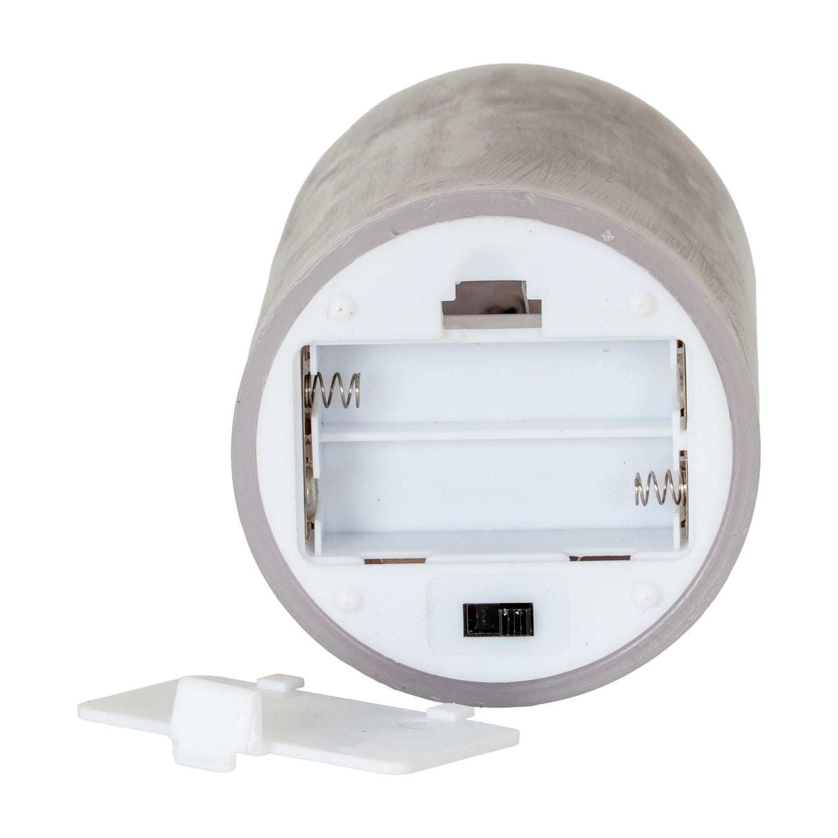 Underside of Hill Interiors Melt Effect LED Wax Pillar Candle in grey, showing open AAA battery compartment, on/off switch and detached white cover.