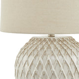 Close-up of Hill Interiors Lattice Ceramic Table Lamp base in white with raised diamond lattice texture, topped by a natural linen drum shade.
