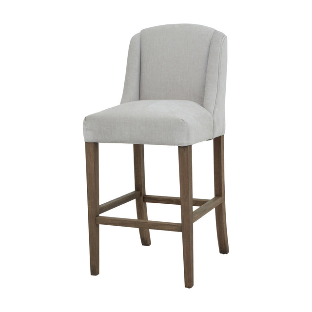 Hill Interiors Braxdon Wooden Bar Stool in grey upholstery with a curved wingback and wood legs joined by stretchers, shown on a plain white background.