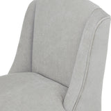 Close-up of the Hill Interiors Braxdon wooden bar stool showing its grey upholstered seat, curved back and piped side detail on a plain background.