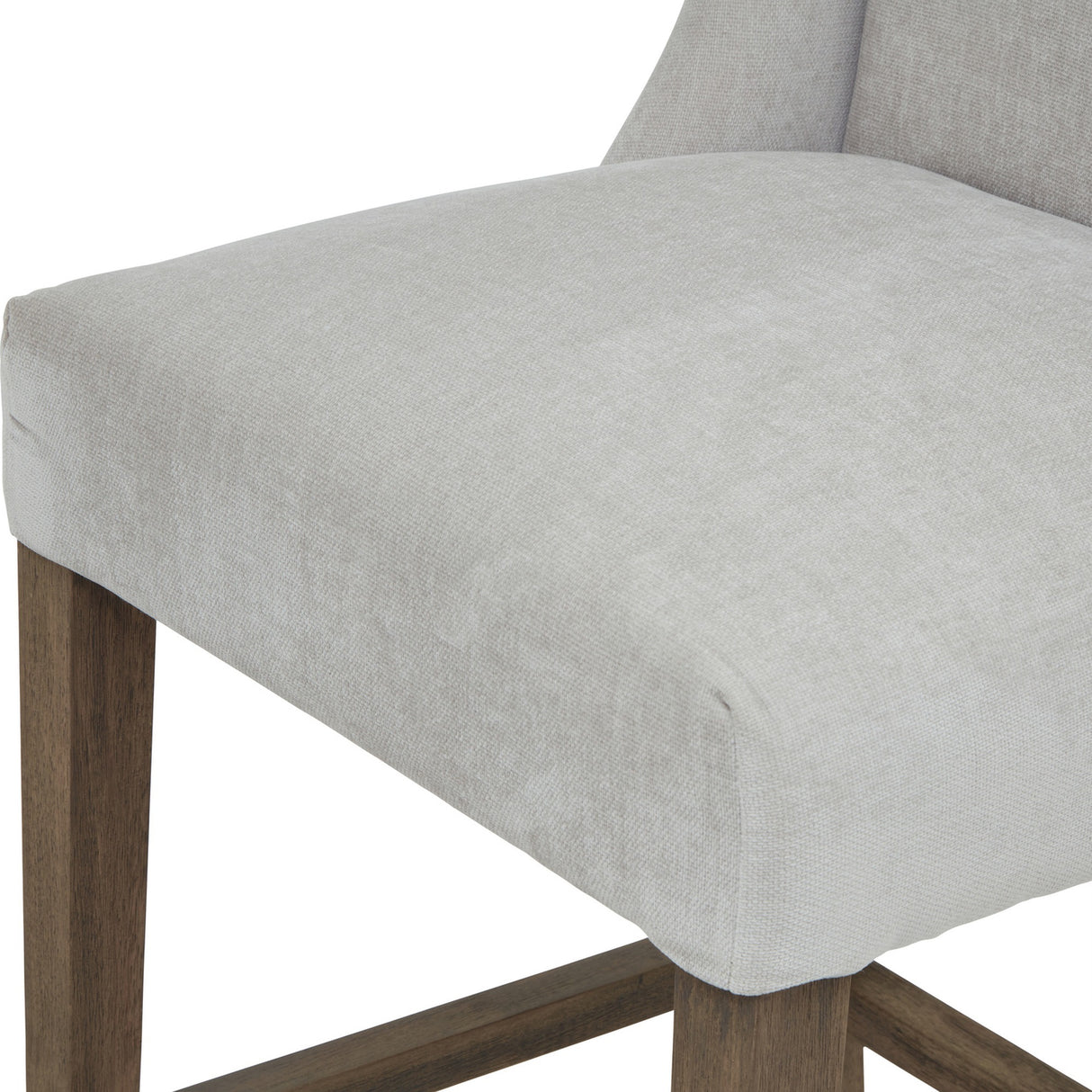 Close-up of the Hill Interiors Braxdon Wooden Bar Stool in grey, showing the padded seat cushion, low upholstered back and wooden leg detail.