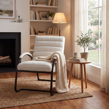 Hill Interiors Ribbed Ark Accent Chair in cream ribbed upholstery with black metal frame, styled with knit throw beside a fireplace and bookshelf.