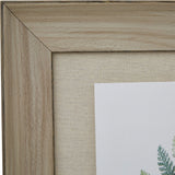 Corner detail of Hill Interiors Framed Fern Duo Print showing the washed brown grained wood frame and linen-textured mount around the botanical print.