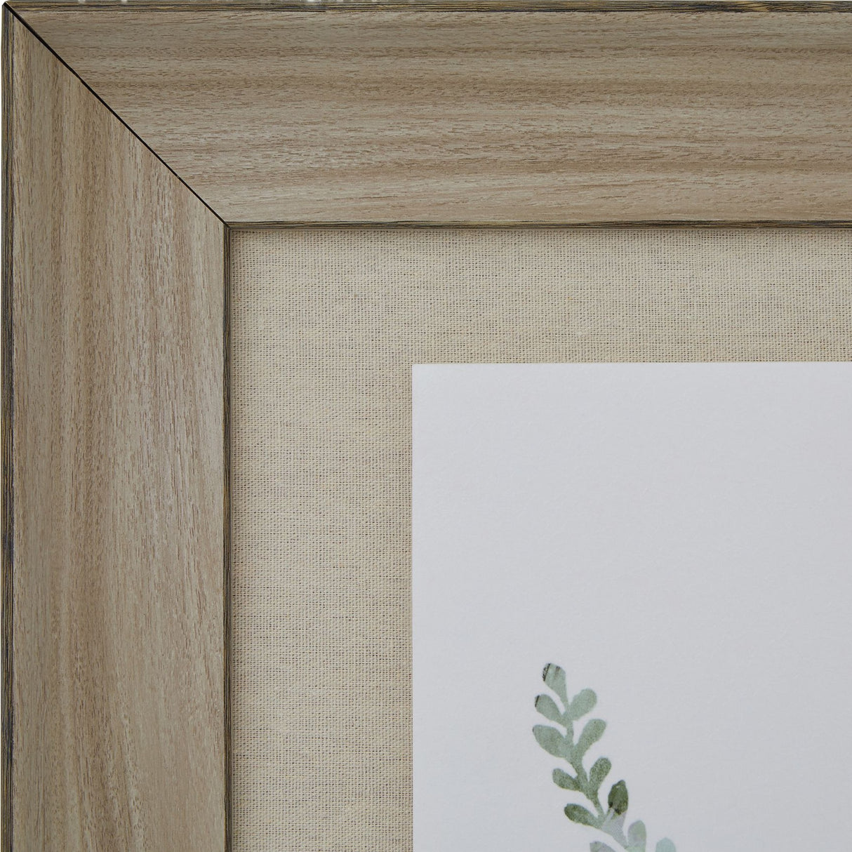 Close-up of the Hill Interiors Delicate Fern Print corner, showing the washed pale brown wood frame, linen-style mount and soft green fern detail.