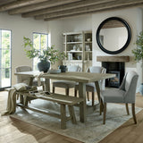 Hill Interiors grey ceramic water pot planter with rounded body holding tall foliage on a rustic dining table in a beamed country room.