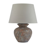 Hill Interiors Lumbriden round ceramic table lamp with weathered brown glazed base and tapered natural linen shade, shown on a plain white background.