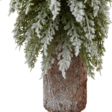 Close-up of Hill Interiors Small Snowy Fir Tree on Tall Wood Log, showing frosted green branches above a brown wood-grain plastic log base.