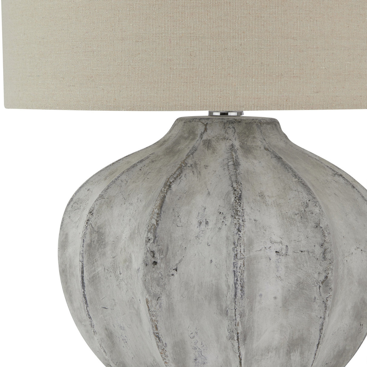 Close-up of the Hill Interiors Merenza fluted ceramic table lamp base in antique white, showing vertical ridges beneath a neutral linen shade.