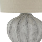 Close-up of the Hill Interiors Merenza fluted ceramic table lamp base in antique white, showing vertical ridges beneath a neutral linen shade.
