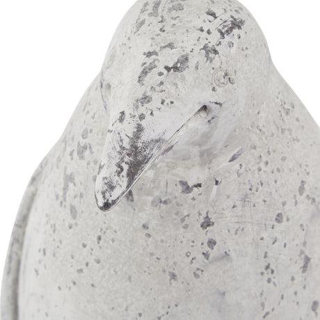 Close-up of the Hill Interiors Small Stone Effect Penguin Statue in beige, showing its ceramic beak and weathered, speckled stone-effect finish.