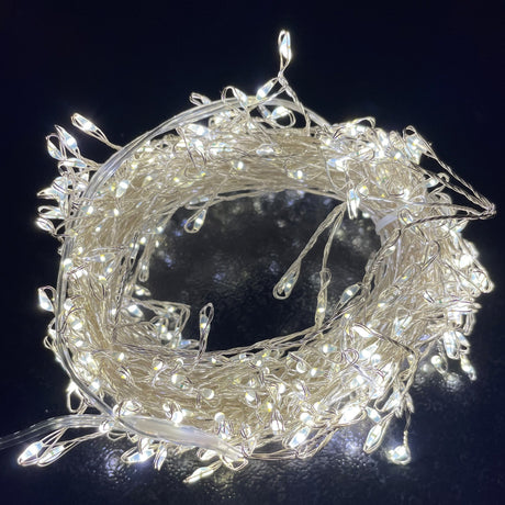 Hill Interiors 7.2m plug in LED warm white cluster micro lights coiled into a ring on a dark background, showing densely packed bulbs on silver wire.