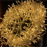 Hill Interiors 13.6m plug in LED string light coiled into a dense bundle, glowing warm white along a slim clear cable.