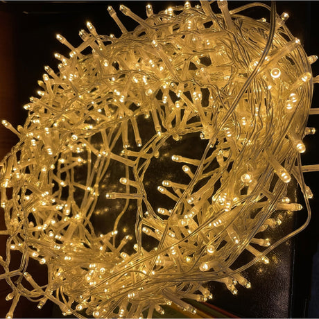 Hill Interiors 13.6m plug in LED string light coiled into a dense bundle, glowing warm white along a slim clear cable.