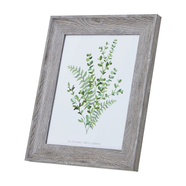 Hill Interiors grey washed wooden photo frame with an 8x10in aperture displaying a green botanical print, shown angled against a plain white background.