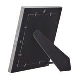 Rear view of Hill Interiors grey washed wooden photo frame showing black backing board, hanging tabs and fold-out kickstand on a white background.