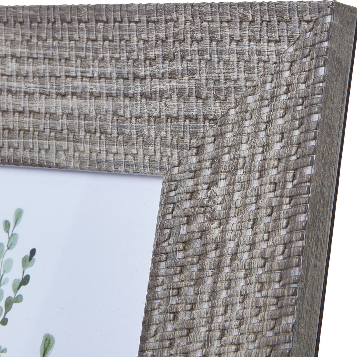 Close-up of the Hill Interiors Woven Photo Frame in grey, showing the textured woven wooden surface at the corner with a hint of botanical print inside.