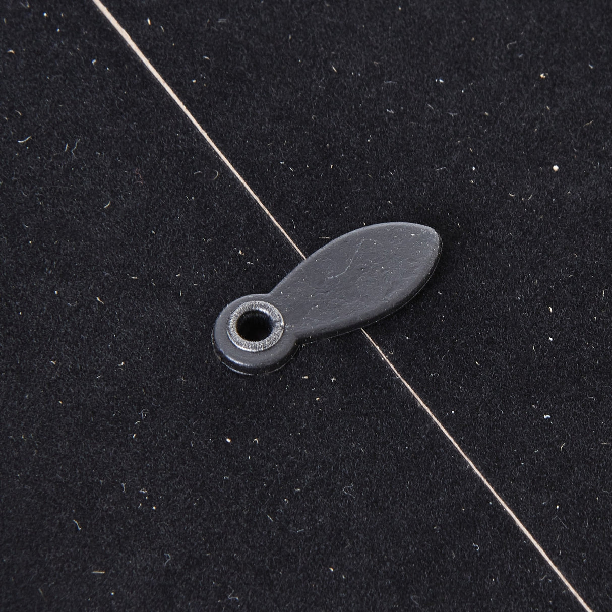 Close-up of the black metal hanging tab and mounting hole on the reverse of the Hill Interiors Woven Photo Frame in grey.