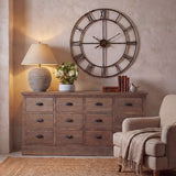 Hill Interiors ceramic table lamp with ribbed brown base and natural linen shade, lit on a rustic wooden dresser beside books and a large wall clock.