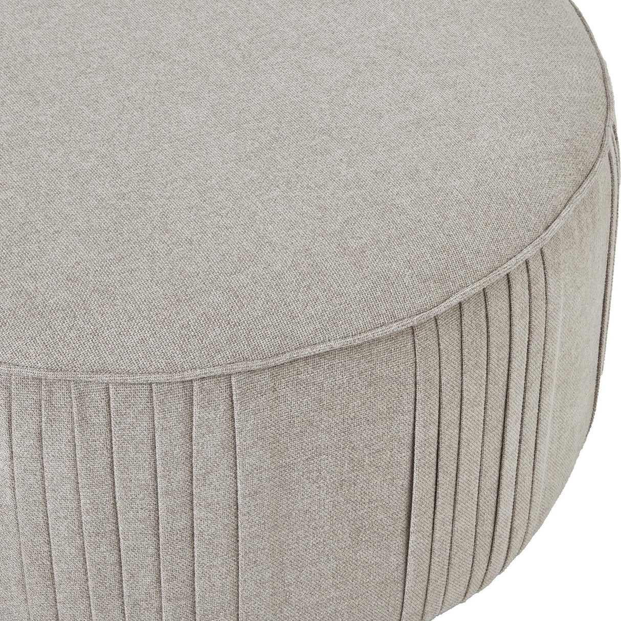 Close-up of Hill Interiors Swivel Ottoman in oatmeal twill cream upholstery, showing the cushioned rounded top and vertical pleated stitching along the side.
