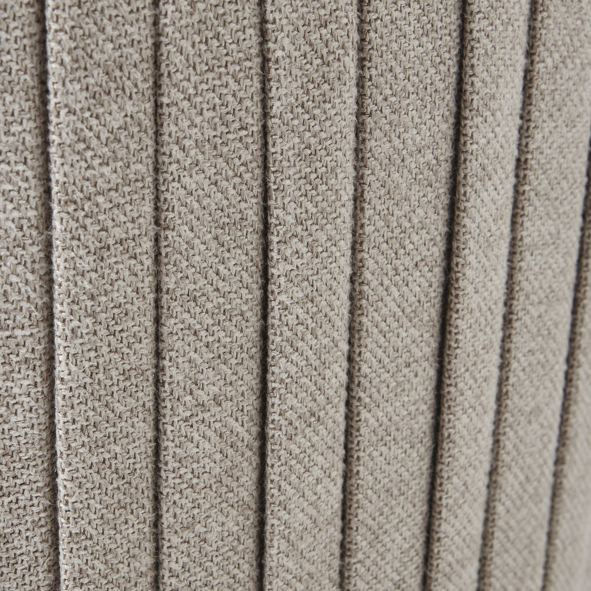 Close-up of the Hill Interiors Swivel Ottoman's oatmeal twill upholstery, showing the vertical ribbed panels and softly textured cream woven fabric.
