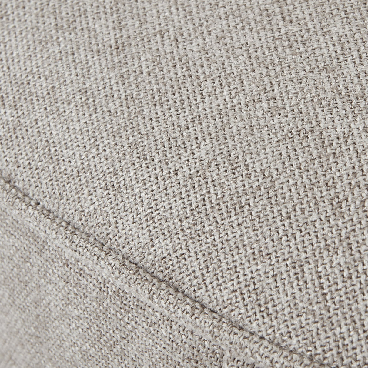 Close-up of the Hill Interiors Swivel Ottoman's oatmeal twill upholstery, showing the woven cream fabric texture and a seam detail.