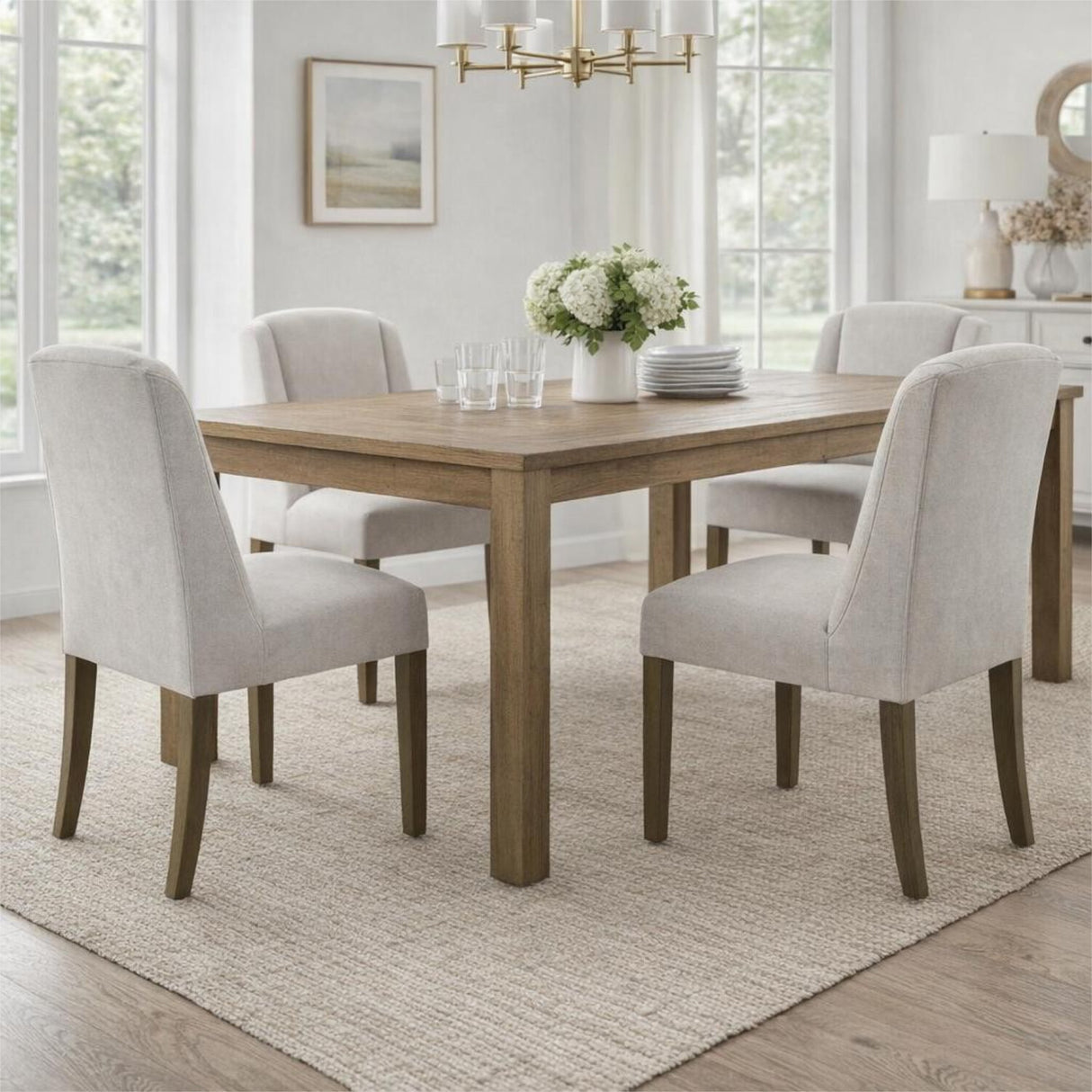 Hill Interiors Braxdon Aspen dining chairs with cream upholstered seats and wooden legs around a natural oak table in a bright dining room.