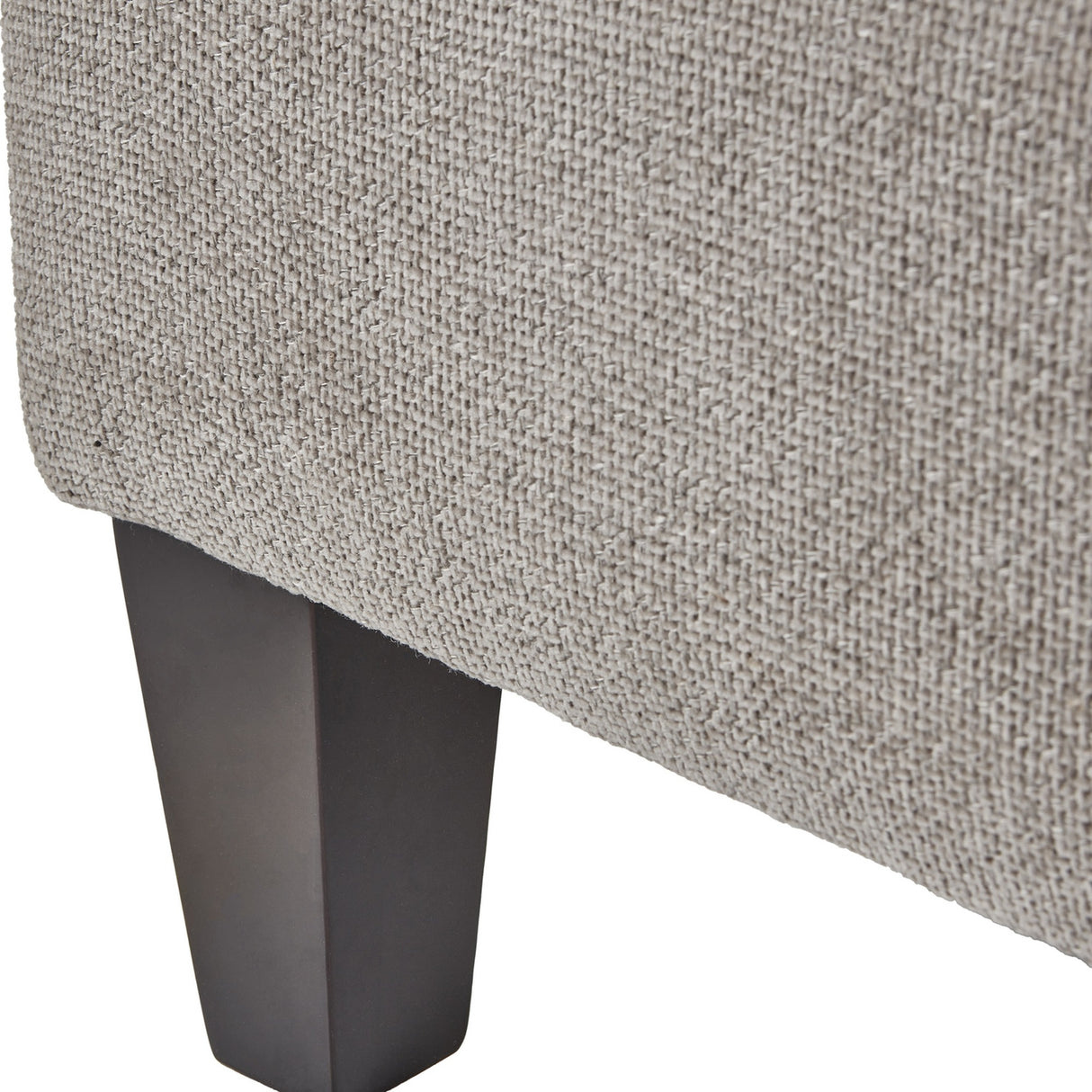 Close-up of the Hill Interiors Upholstered Ottoman Foot Stool showing beige woven fabric and a tapered dark wooden leg against a white background.