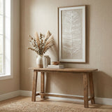 Hill Interiors Large Feather Wall Art in a beaded frame hangs above a wooden console table with a vase of pampas and eucalyptus in a neutral hallway.