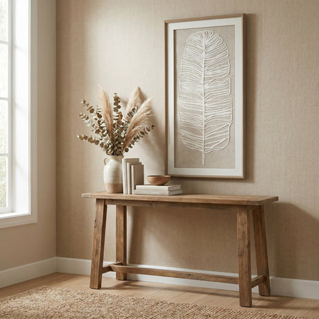 Hill Interiors Large Feather Wall Art in a beaded frame hangs above a wooden console table with a vase of pampas and eucalyptus in a neutral hallway.