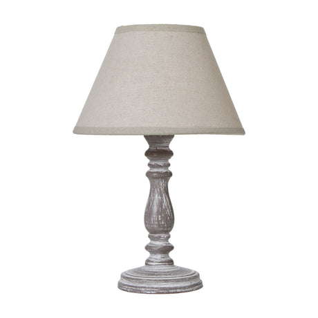 Hill Interiors Column Table Lamp with turned wooden base in distressed white finish, topped with a tapered natural linen shade, on a plain background.