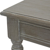 Close-up of Hill Interiors Rattan Coffee Table in brown, showing the distressed wood corner, panelled apron detail and turned leg.
